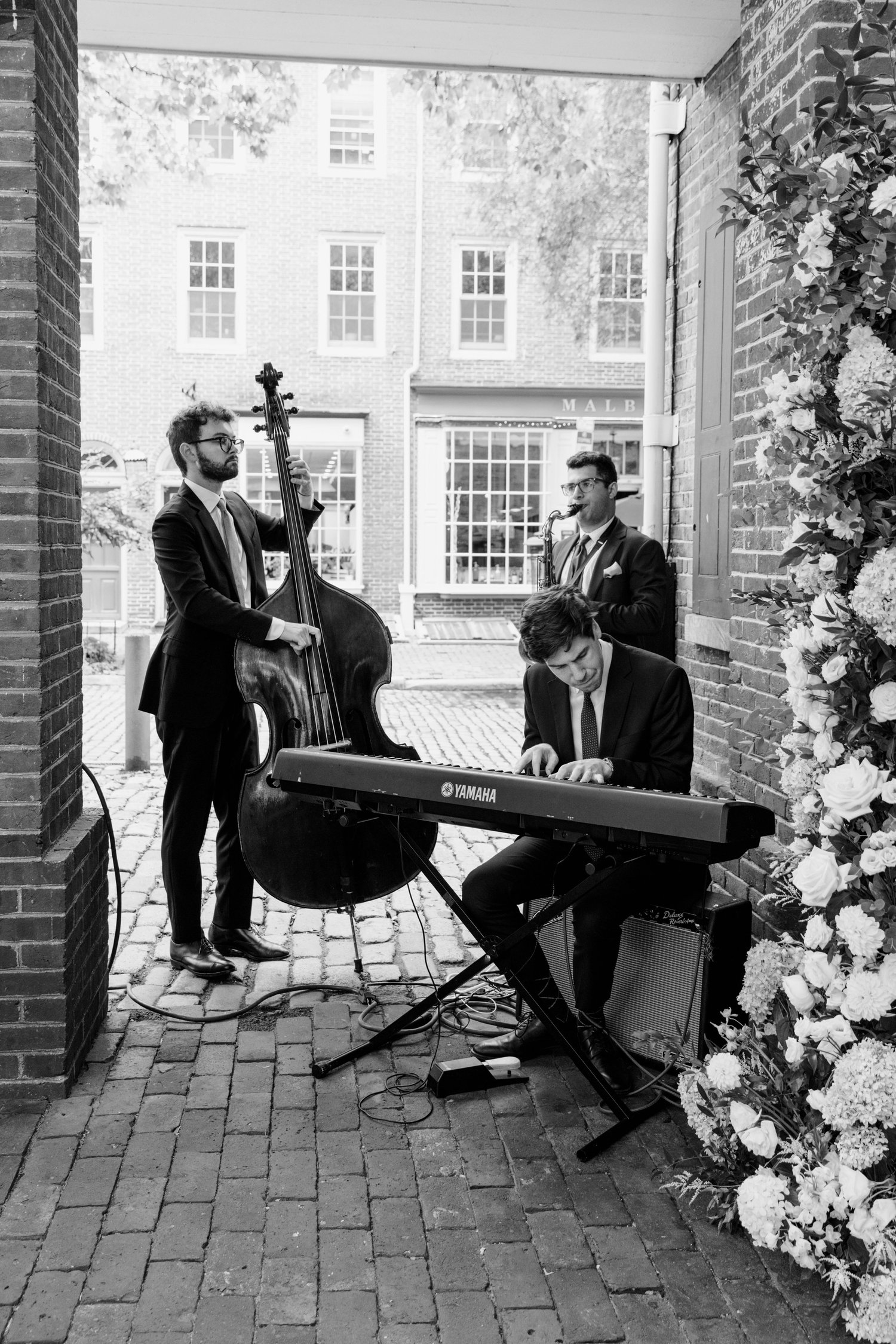 The trio playing under a brick archway